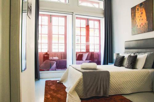 a bedroom with a bed and a large window at Hannah's Studios in Porto