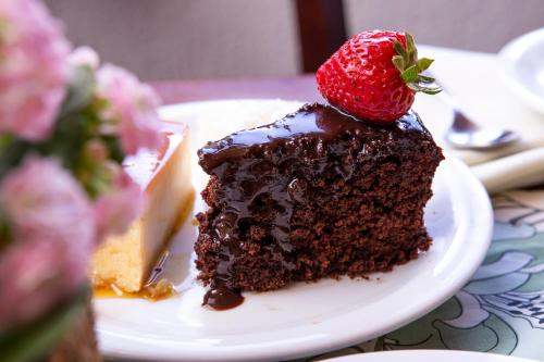 a piece of chocolate cake with a strawberry on top at Hotel Praia do Portinho in Ilhabela
