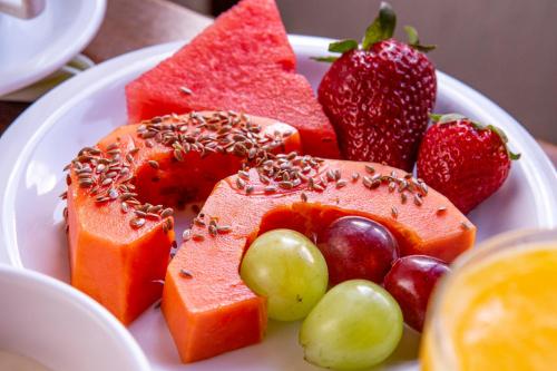 a plate of fruit and vegetables on a table at Hotel Praia do Portinho in Ilhabela