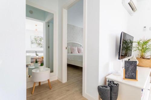 una stanza con una camera da letto con un letto e uno specchio di The Little White House, Suite Flower Beach 9 a Playa Honda