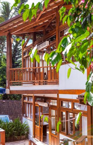 a wooden pergola with glass doors on a building at Hotel Praia do Portinho in Ilhabela