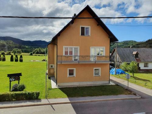 a house with a balcony on the side of the street at Apartman Orhideja in Fužine