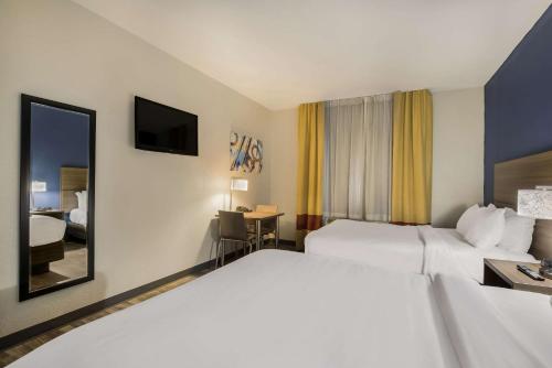 um quarto de hotel com duas camas e um espelho em MainStay Suites Joliet I-80 em Joliet