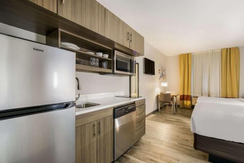 a kitchen with a refrigerator and a bed in a room at MainStay Suites Joliet I-80 in Joliet