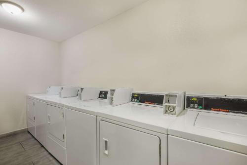 uma fila de máquinas de lavar roupa brancas num quarto em MainStay Suites Joliet I-80 em Joliet