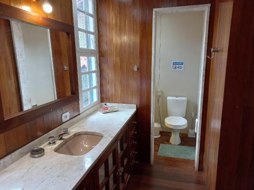 a bathroom with a sink and a toilet at Pousada Solar Azul in Miguel Pereira