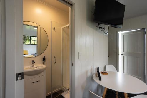 a small bathroom with a sink and a mirror at GLENALMOND Historic Homestead & Alpine Country Stay in Harihari