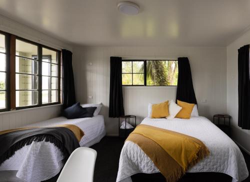 two beds in a room with two windows at GLENALMOND Country Motels in Harihari