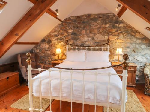 a bed in a room with a stone wall at Carnorfa in Newport Pembrokeshire