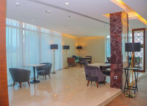 a lobby with tables and chairs in a building at Radisson Blu Hotel, Juba in Juba