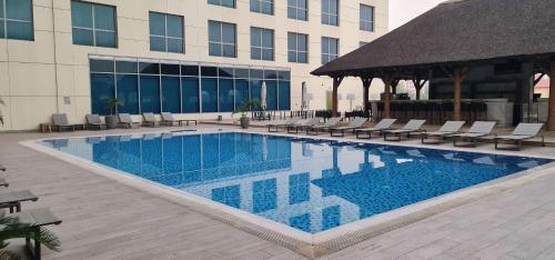 a large swimming pool with chairs and a building at Radisson Blu Hotel, Juba in Juba