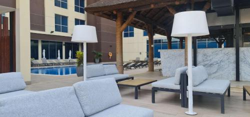 a patio with chairs and tables and a pool at Radisson Blu Hotel, Juba in Juba