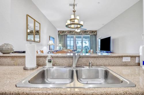 a stainless steel sink in a kitchen with a television at Fairway Vista in Naples