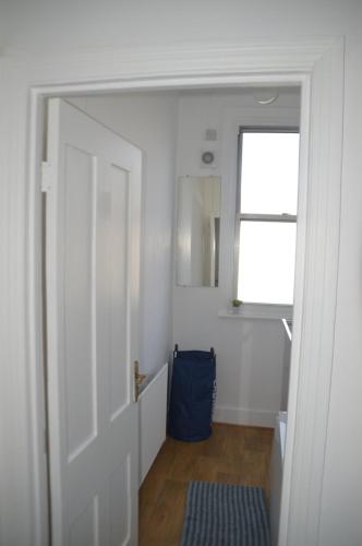 a hallway with a door leading to a bathroom with a window at Two Bedroom Apartment in London in London