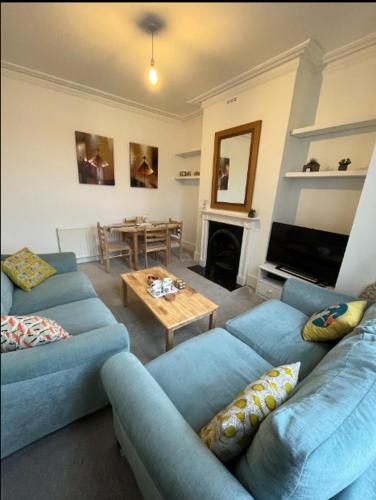 a living room with two blue couches and a table at Two Bedroom Apartment in London in London