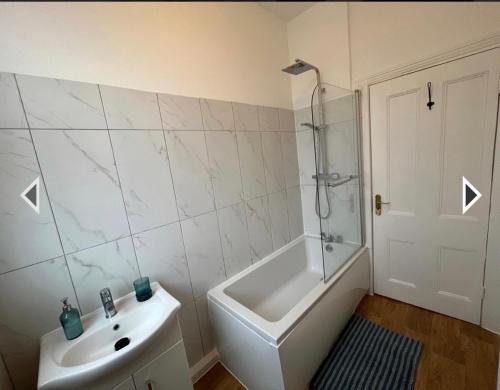 a white bathroom with a shower and a sink at Two Bedroom Apartment in London in London