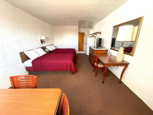 a hotel room with a red bed and a desk at Cardinal Motel in North Wildwood