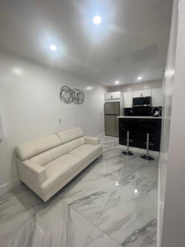 a living room with a white couch and a kitchen at Villa San Carlos Park in Fort Myers