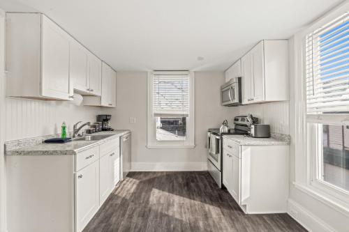 a white kitchen with white cabinets and a sink at Family Friendly 2 Floor 2 BR Apt [Sunflower Stay] 