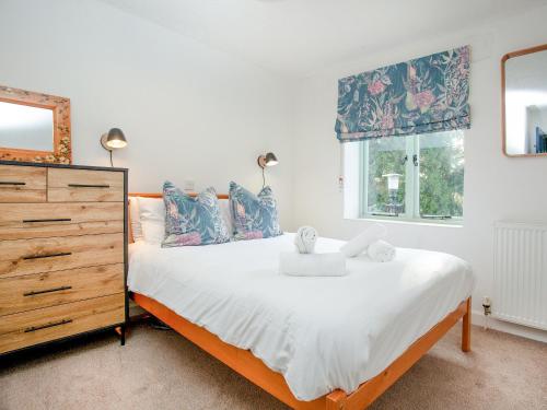 a bedroom with a large bed and a dresser at Barley Cottage in Brownston