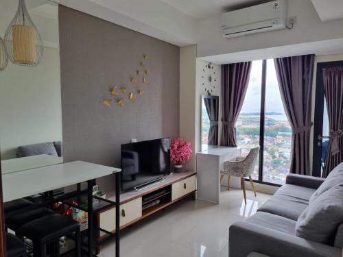 a living room with a couch and a tv at Amazing view 2 bedrooms new apartment in Batam Center