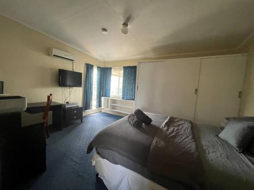 een hotelkamer met een bed en een televisie bij 3 bedroom house in great location in Goondiwindi