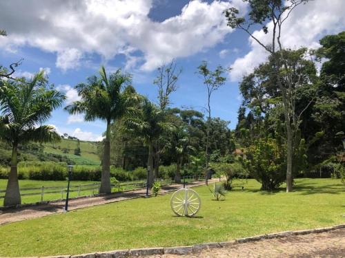 a metal object in a park with palm trees at Pousada Solar Azul in Miguel Pereira