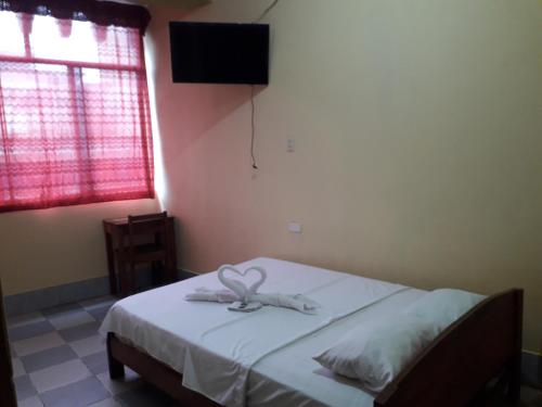 Un dormitorio con una cama con una toalla. en Hospedaje callao, en Moyobamba