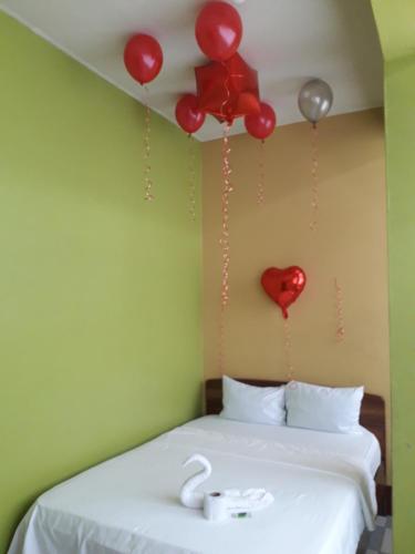 Habitación con cama con globos rojos en la pared en Hospedaje callao, en Moyobamba