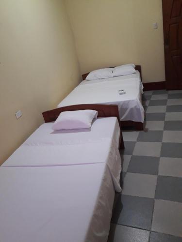 2 camas en una habitación con suelo a cuadros en Hospedaje callao, en Moyobamba