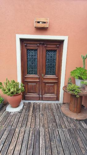 una puerta de madera de un edificio con dos macetas en Los Cardales Mia en Los Cardales