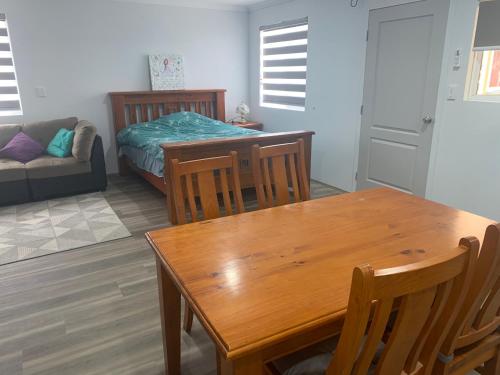 a living room with a table and a bed at Lovely large studio in canning vale in Perth