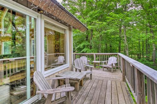 a wooden porch with chairs and a table on it at Conway Area Chalet with Mountain Views and Fire Pit! in Madison