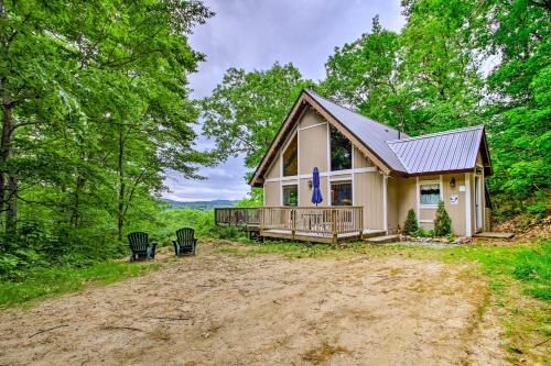 a house on a dirt road in the woods at Conway Area Chalet with Mountain Views and Fire Pit! in Madison