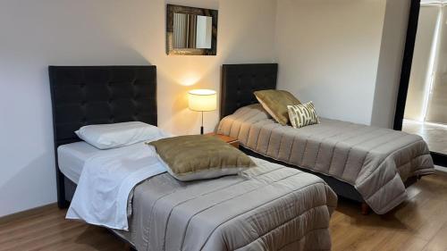 um quarto com duas camas e um candeeiro em Apart Archipiélago em Rosário