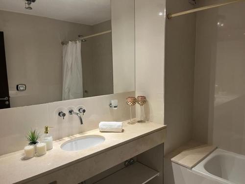 baño con lavabo y espejo grande en Apart Archipiélago en Rosario