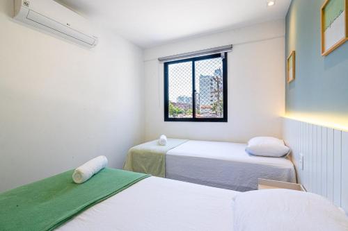 Cette chambre comprend 2 lits et une fenêtre. dans l'établissement 2Q moderno e aconchegante na Praia de Itapoã, à Vila Velha