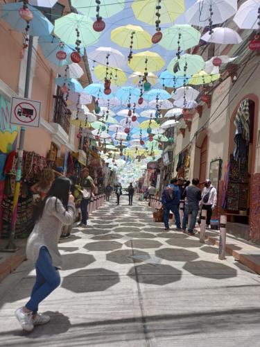 a woman walking down a street under umbrellas at Hotel Nuevo Sol in La Paz