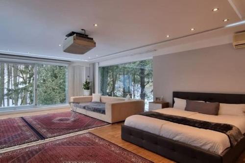 - une chambre avec 2 lits et une grande fenêtre dans l'établissement Haus mit traumhaften Ausblick in die Natur, à Purkersdorf