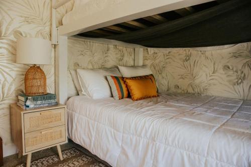 1 dormitorio con 1 cama blanca con dosel en Pink Paradise Inn - 5 BR Fun Retro Home w/ Pool, en Oceanside