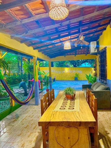 a dining room with a table and a hammock at POUSADA FLORA in Alter do Chao