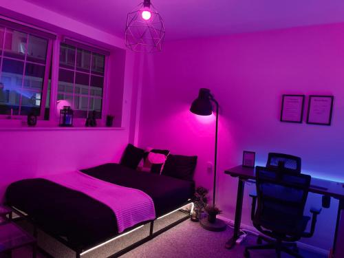 a bedroom with a pink room with a bed and a desk at Comfortable modern (SMART) Studio in Walthamstow. in London