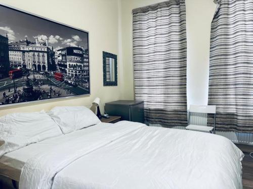 a bedroom with a white bed and two large windows at Valentines Inn in London