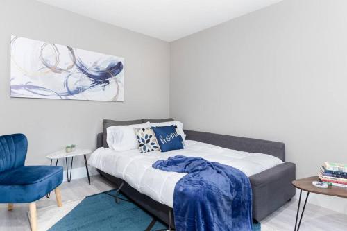 a bedroom with a bed and a blue chair at Modern & Elegant 1-Bedroom Unit in Edmonton