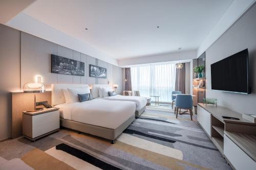 Postel nebo postele na pokoji v ubytování Oaks Chengdu at Cultural Heritage Park