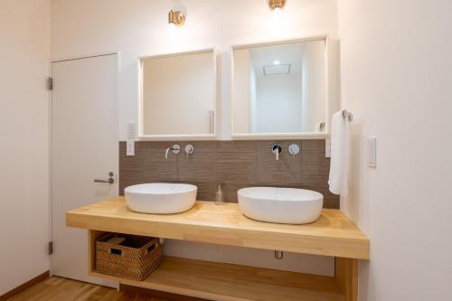 two sinks on a wooden counter in a bathroom at Dennojo in Nozawa Onsen