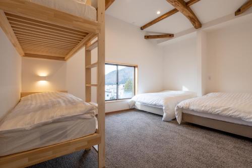 a bedroom with two bunk beds and a window at Dennojo in Nozawa Onsen