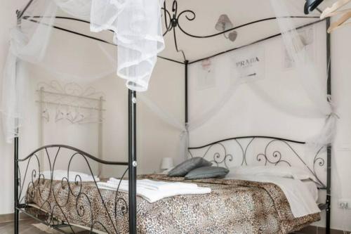 a bedroom with a metal bed with a canopy at B&B CORSO VITTORIO EMANUELE - Nel pieno centro storico in LʼAquila