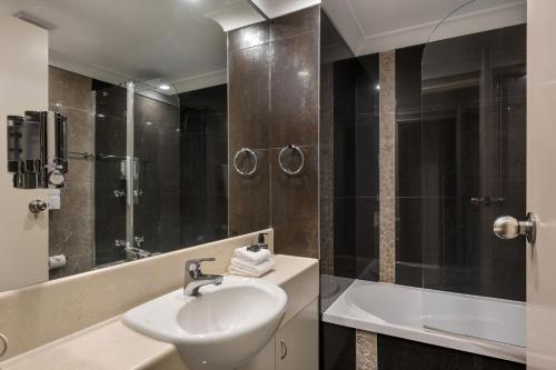 a bathroom with a sink and a shower and a tub at Lantern 1 Bedroom Balcony with mountain View in Thredbo