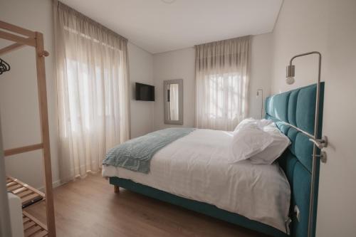 a bedroom with a bed with a green headboard at Albina's Guest House in Leça da Palmeira